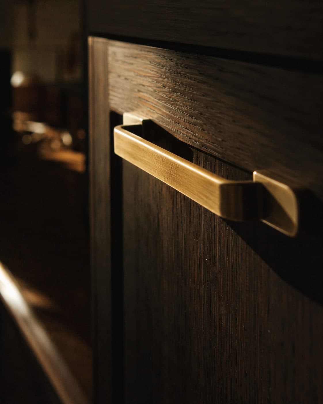 Detail van een messing greep op donker eiken